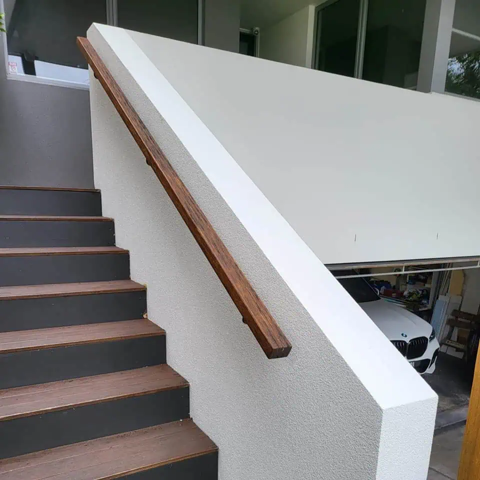 repairing render on steps outside house, with wooden balustrade