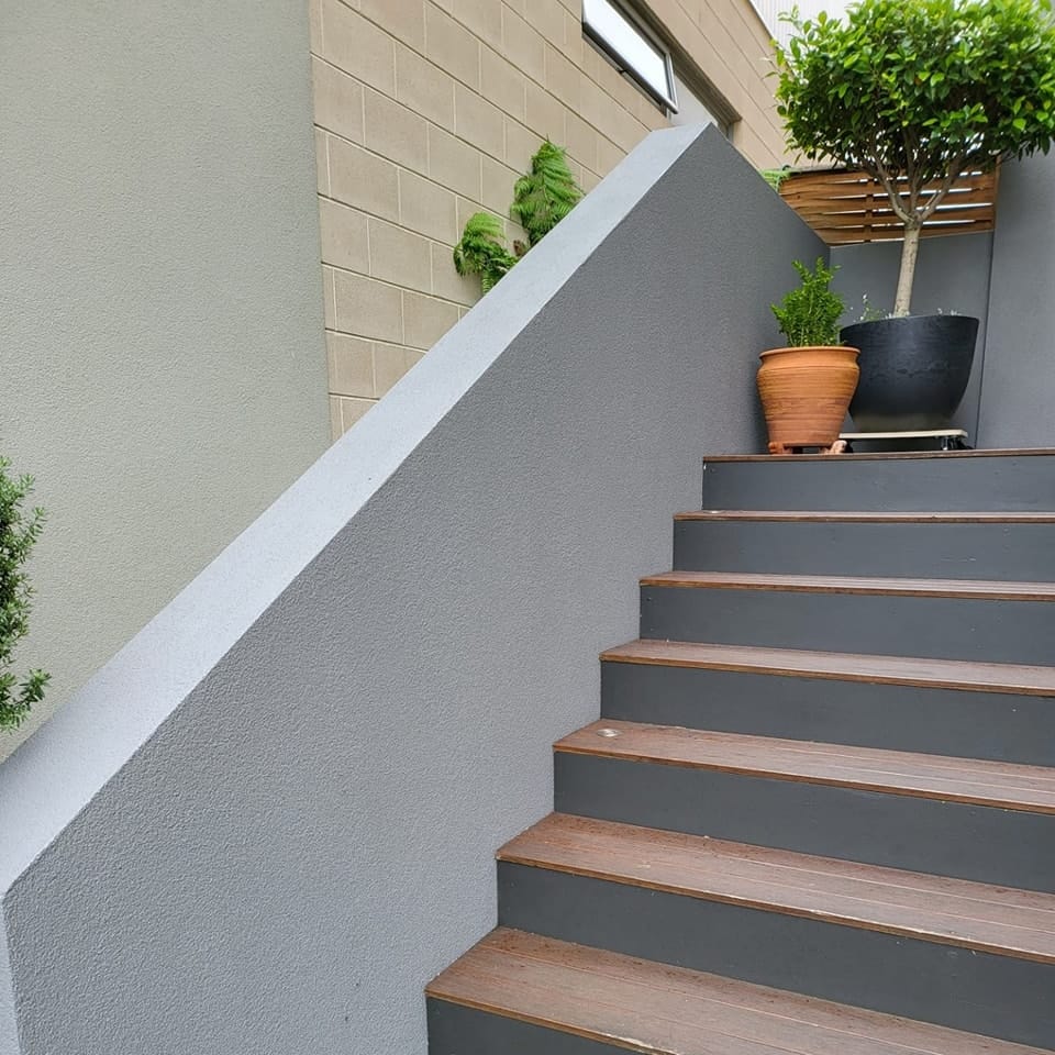 render repair, wall against outdoor stairs from front of house