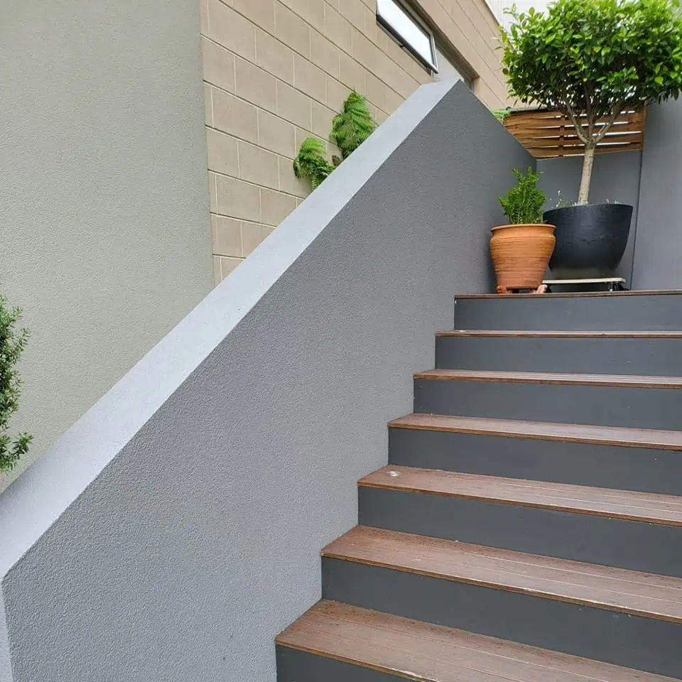 render repair, wall against outdoor stairs from front of house